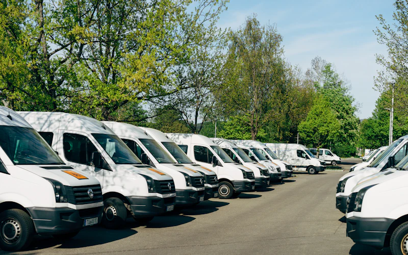 Rij witte bestelbussen op een parkeerterrein